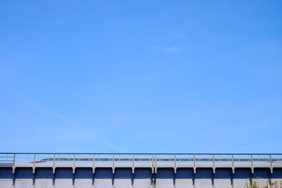 Bridge over sea against clear blue sky