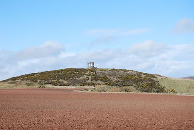 Scenic view of land and mountain against sky