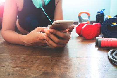 Midsection of man holding coffee cup on table