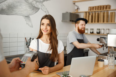 Portrait of smiling friends working in cafe