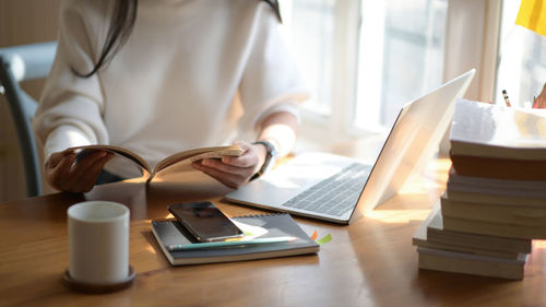 Midsection of woman reading book