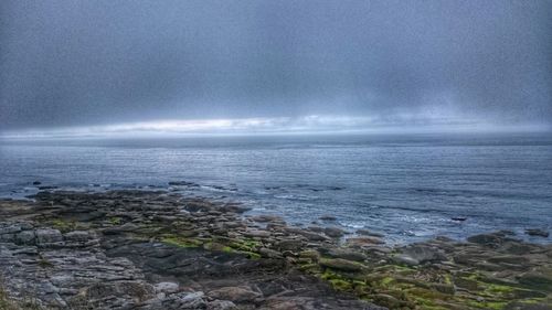 Scenic view of sea against cloudy sky