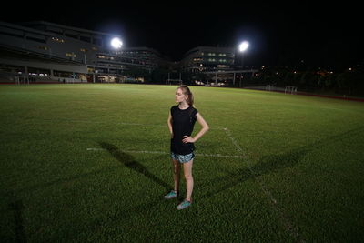 Full length portrait of teenage girl standing at night