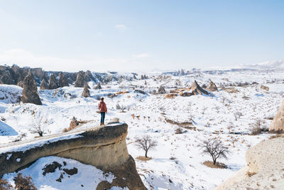 Man standing on snowcapped mountain against sky