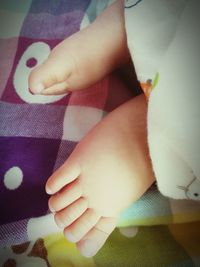 Close-up of baby feet on bed at home