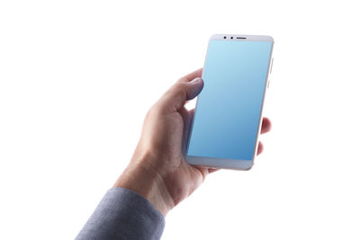 Close-up of hand holding mobile phone over white background