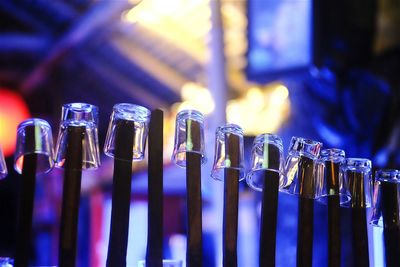 Shot glasses on bamboos at illuminated bar