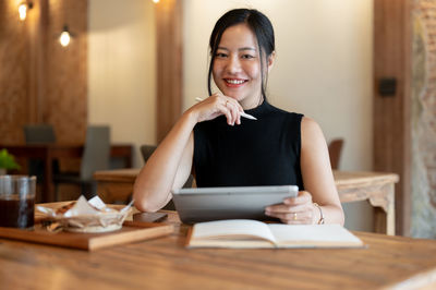 Portrait of young woman sitting on table