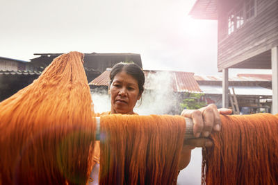 Woman hanging wool on wood outdoors