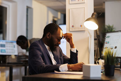 Side view of man using mobile phone in office