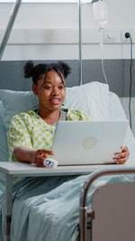 Portrait of young woman using laptop at home