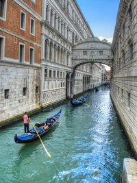 Boats in canal along buildings