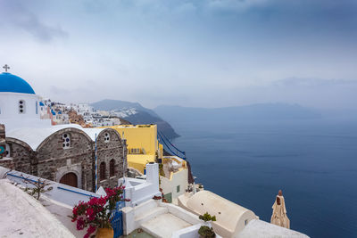 Blue dome  in the village of oia, santorini in a rare  rainy day, greece