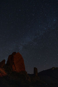 Low angle view of rock formation against sky at night