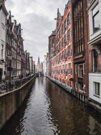 Canal amidst buildings against sky