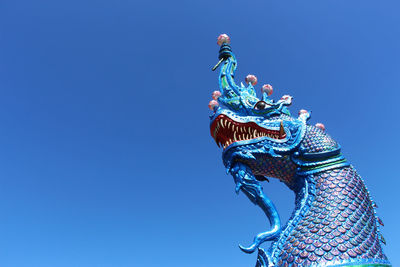 Low angle view of statue against blue sky