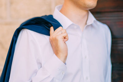 Midsection of man holding coat