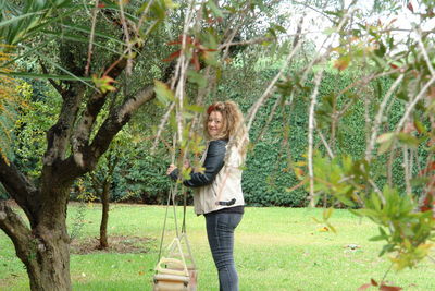 Portrait of smiling young woman standing by plants