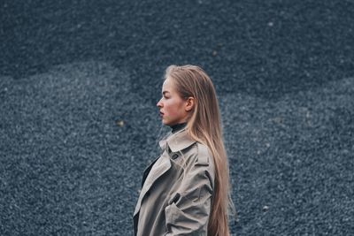 Young woman standing against wall