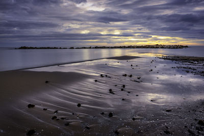 Scenic view of beach against sky during sunset