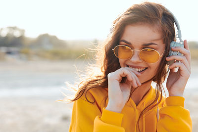 Portrait of young woman wearing sunglasses at beach