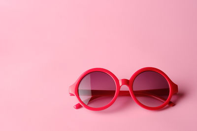 Close-up of sunglasses against pink background