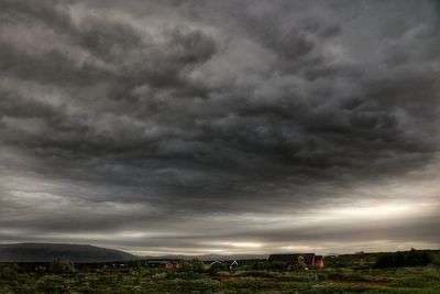 Scenic view of field against cloudy sky