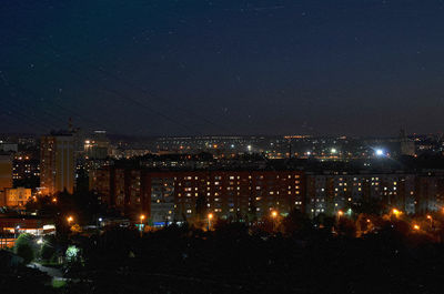 Illuminated cityscape against sky at night