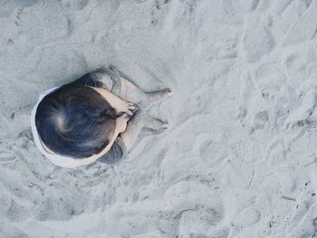 High angle view of girl lying on sand