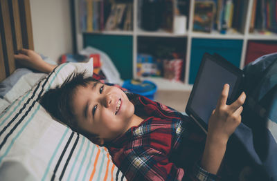 Portrait of happy boy using mobile phone at home