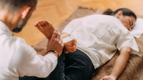 Therapist stretching womans legs. shiatsu massage.