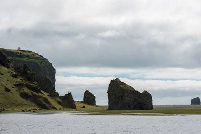 Rock formations by sea against sky