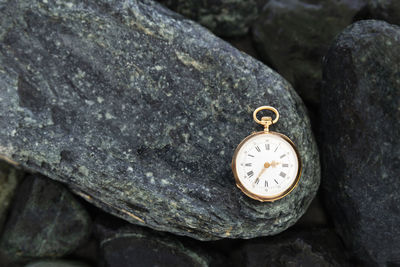 Close-up of pocket watch on rock