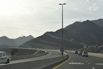 Cars on road against mountain range