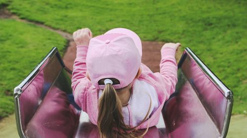 High angle view of girl sliding on slide at playground