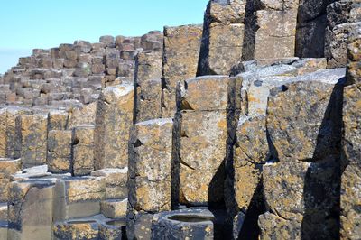 Rocky formations at giant causeway against clear sky