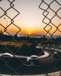 Close-up of chainlink fence during sunset