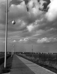 Empty road against cloudy sky