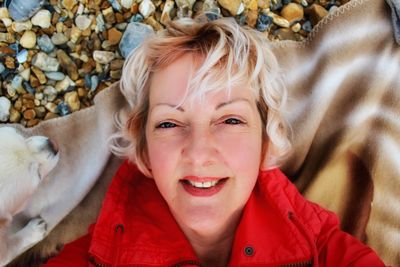 Portrait of smiling young woman lying on stone