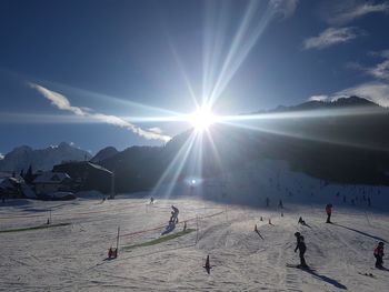 People skiing on snowcapped mountain against sky