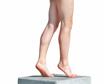 Low section of woman standing against white background