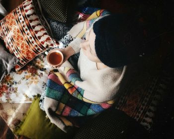 High angle view of man holding drink sitting on table