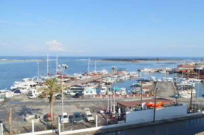 Boats moored at harbor in sea against sky