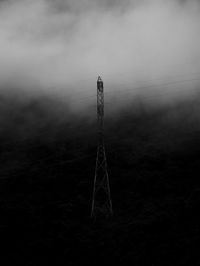 Electricity pylon on field against sky