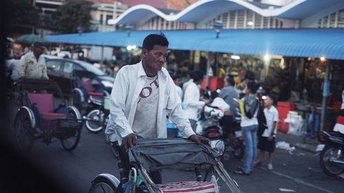 Man with bicycle on road in city