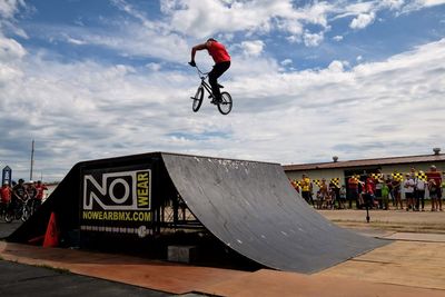 Low angle view of man jumping against sky