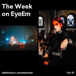 Portrait of young woman standing against illuminated window at night