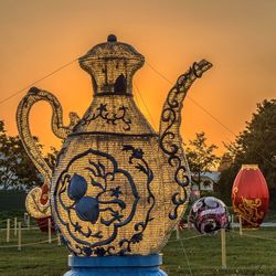 Illuminated sculpture against sky during sunset