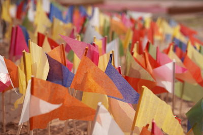 Close-up of multi colored flags hanging on paper