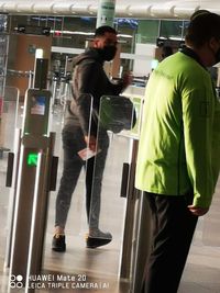 Rear view of people walking on glass